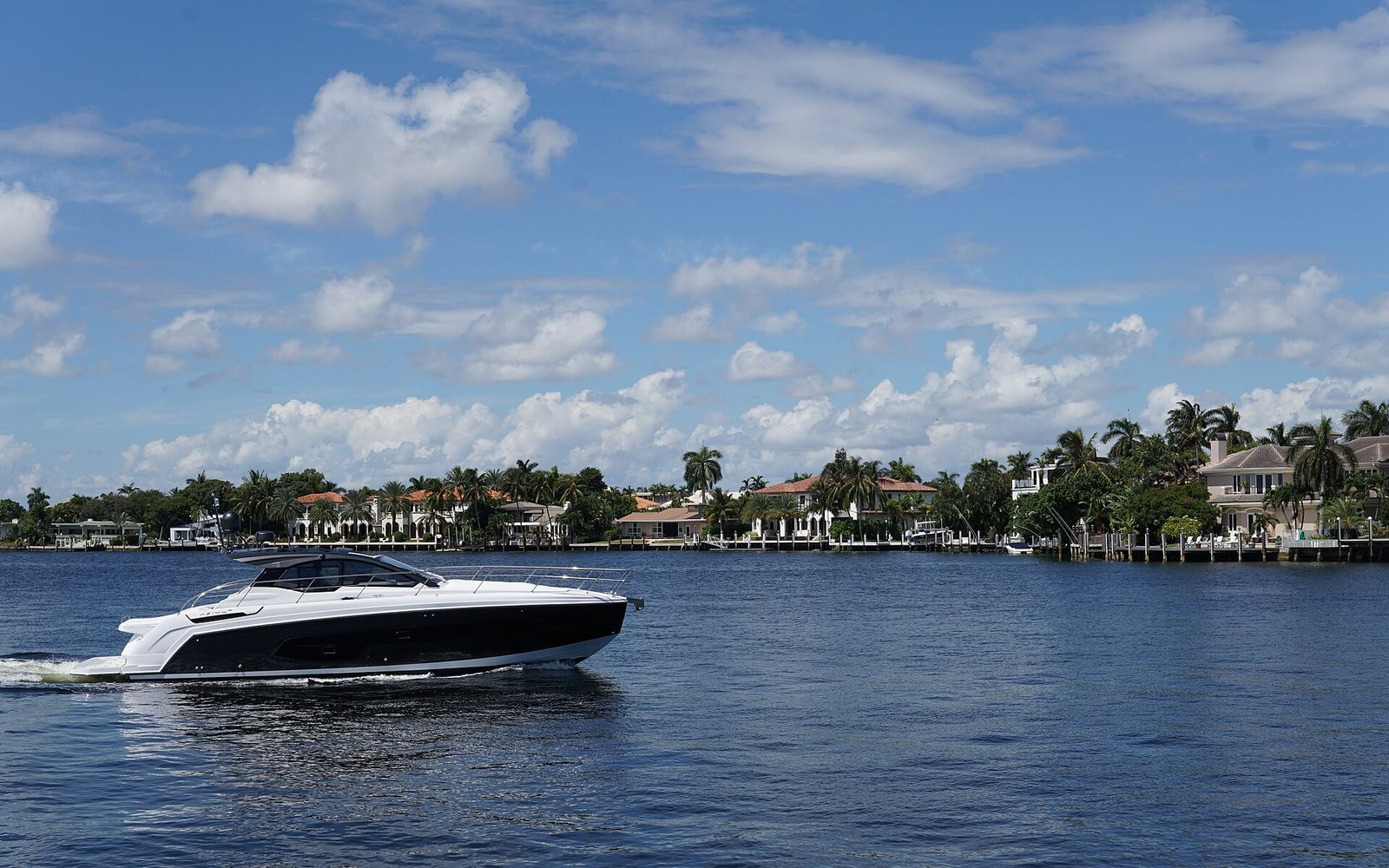 Boat on the Intracoastal Waterway between waterfront homes in Fort Lauderdale